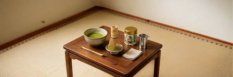 A complete matcha set laid out with a chawan bowl, bamboo whisk, scoop, holder, and sifter.