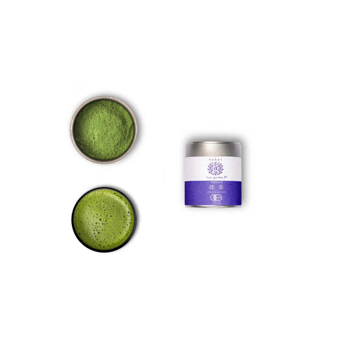 A tin container of Wazuka Tea Nakai Superior next to a bowl and a dish of matcha powder